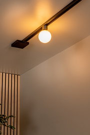 Deckenstrahler TYCHO in Schwarz mit Glas, montiert an einer Schiene, seitliche Perspektive