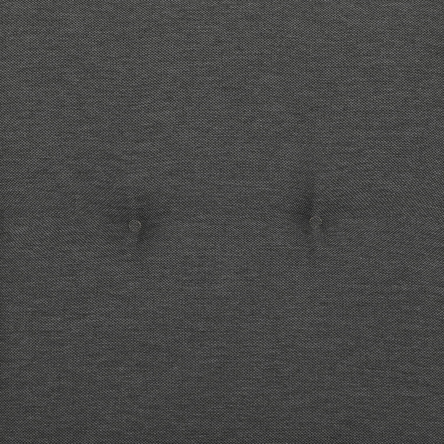 Nahaufnahme einer grauen Sesselauflage mit Knopfdetails in der Mitte.