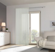 Heller Fertigvorhang Miriam in einem modernen Wohnzimmer, aufgehängt vor einer großen Fensterfront mit Blick ins Freie.