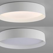 Runde, flache LED-Deckenleuchte in Weiß mit breitem Ring und opalem Diffusor, eingeschaltet mit warmweißem Licht; Perspektive: leicht von unten im schrägen Seitenwinkel.