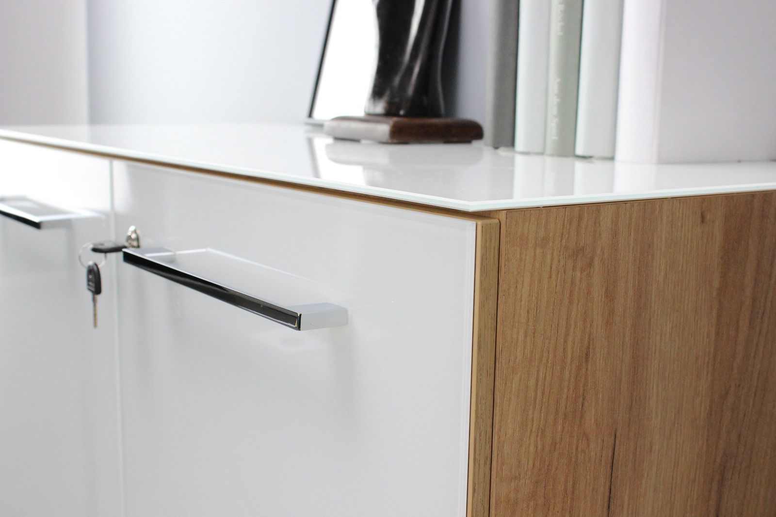 Nahaufnahme eines modernen Aktenschranks mit weißer Front und Holzseiten, seitliche Perspektive.