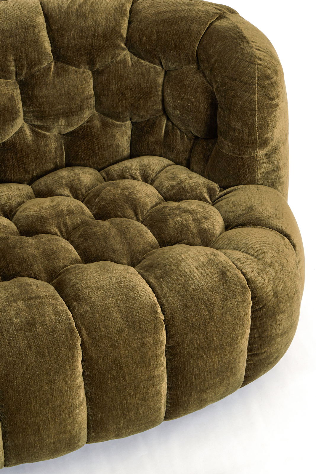 Nahaufnahme einer olivgrünen Couch mit weichem, gepolstertem Stoff und runder Form.