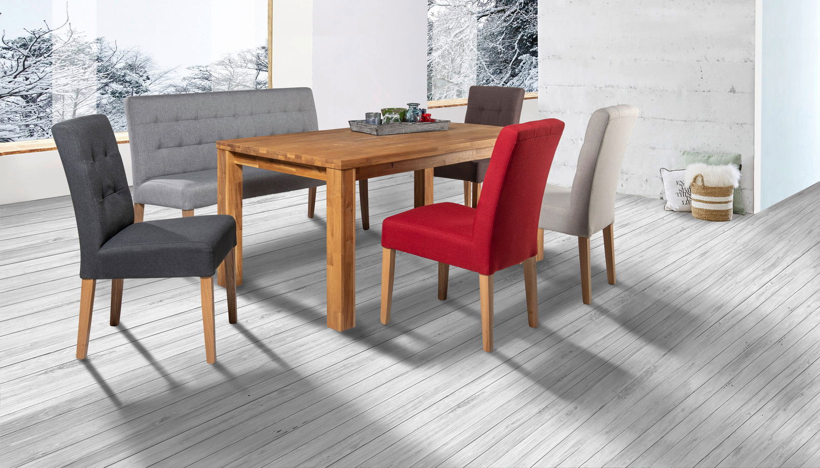 Esszimmer mit Holztisch und verschiedenen Stühlen in einem modernen Raum mit großen Fenstern und winterlicher Aussicht, seitliche Perspektive.