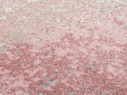 Nahaufnahme eines Designer Teppichs in Rosa- und Beigetönen mit weicher, flauschiger Textur.