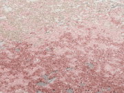 Nahaufnahme eines Designer Teppichs in Rosa- und Beigetönen mit weicher, flauschiger Textur.