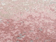 Nahaufnahme eines Designer Teppichs in Rosa- und Beigetönen mit weicher, flauschiger Textur.