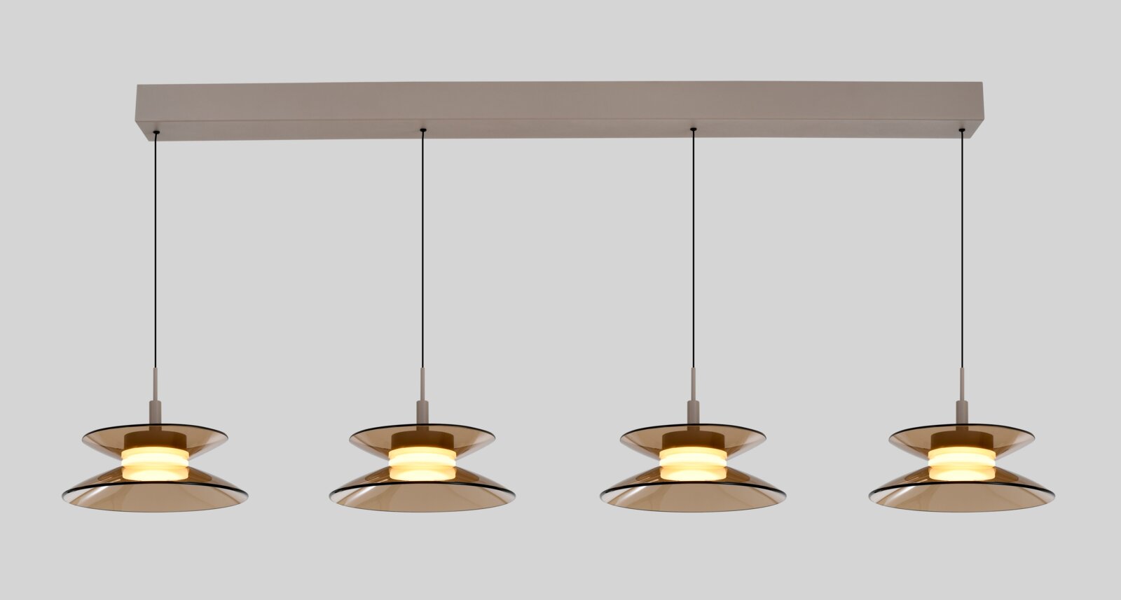 Vooraanzicht van een moderne viervoudige hanglamp met amberkleurige glazen kappen, warmwitte verlichting en een langwerpige plafondbalk