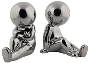 Zwei silberne, glänzende Buchstützen in Form von stilisierten, sitzenden Figuren. Die Figuren sind aus einer frontalen Perspektive zu sehen.