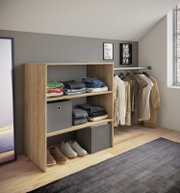 Offenes Kleiderschrank-Regal in heller Holzoptik mit gefalteter Kleidung, Stoffboxen und Schuhen, daneben Kleiderstange mit Bügeln; Perspektive: leicht seitliche Frontansicht von links auf Augenhöhe.