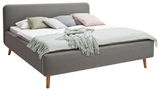 Graues Polsterbett mit Holzbeinen, dekoriert mit mehreren Kissen und einer Decke, seitliche Perspektive