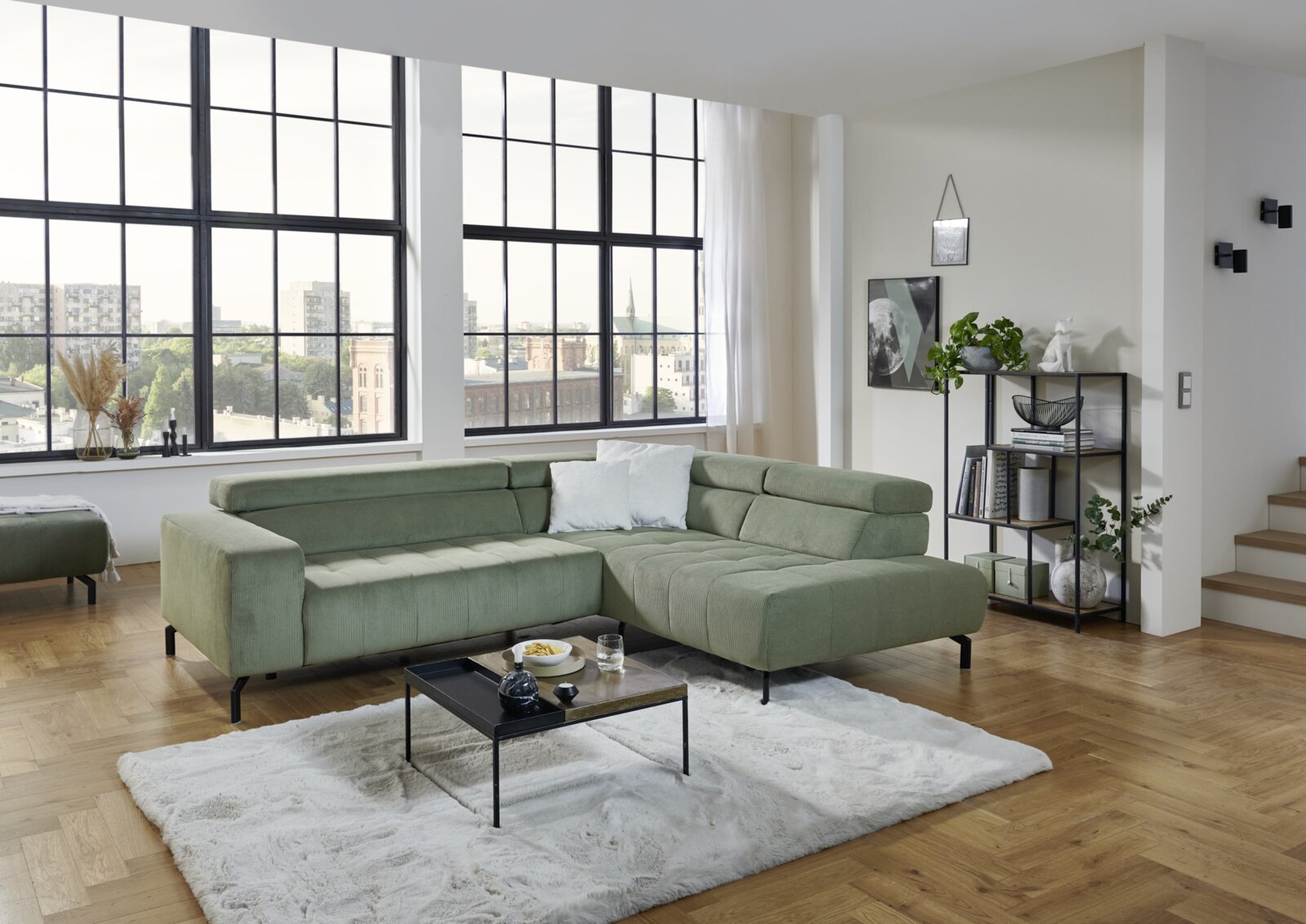 Beldomo Style Ecksofa ZELL Grüne Eckgarnitur in modernem Wohnzimmer mit großen Fenstern, aus der Perspektive von vorne rechts fotografiert.