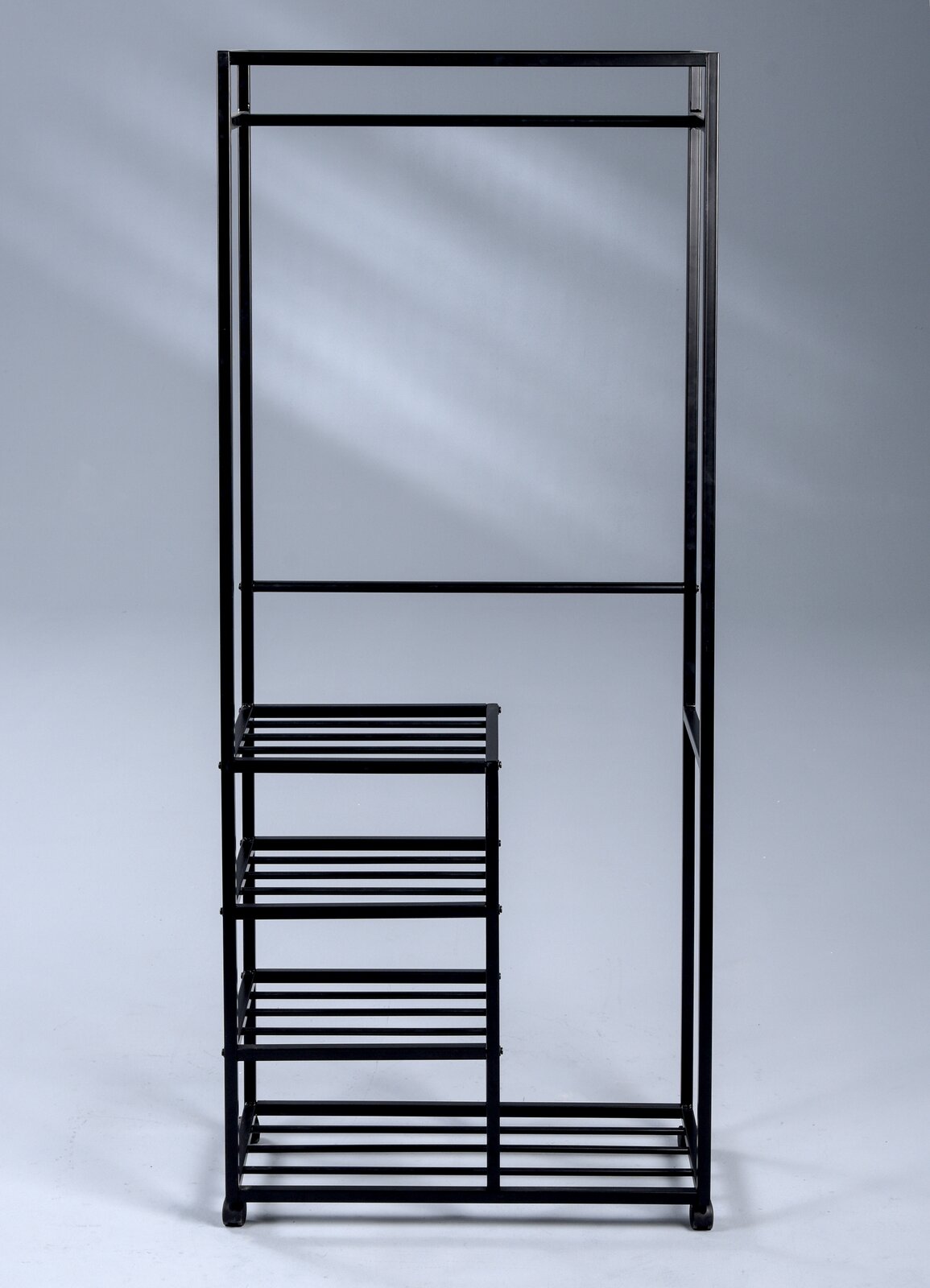 Schwarzer Garderobenwagen aus Metall mit Kleiderstange und mehreren Regalböden, seitliche Perspektive.