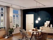 Moderne Wohnzimmerbeleuchtung mit zwei hängenden Glühbirnen an einem URAIL-System, seitliche Perspektive.