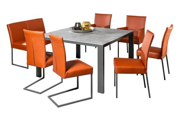 Musterring Bank MR NOVA Essgruppe mit einem quadratischen Tisch und sechs orangefarbenen Stühlen, Perspektive leicht von oben.