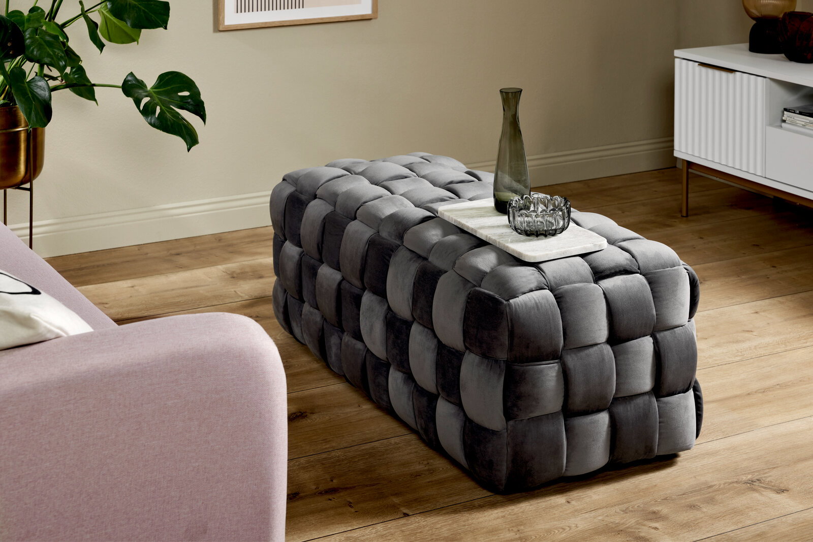 Jahnke Hocker WEB ART Grauer, gepolsterter Hocker in rechteckiger Form mit geflochtenem Design, seitliche Perspektive.