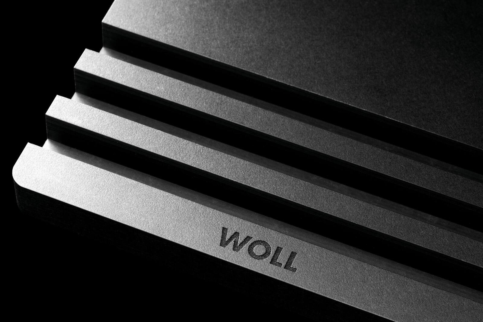 Woll Schneidebrett-Halter CULT & SERVE Nahaufnahme eines gestapelten Schneidebrett-Halters mit dem Schriftzug 'WOLL' in einer diagonalen Perspektive.