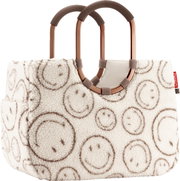 Flauschige Handtasche aus Teddyplüsch in Creme mit Smiley-Muster, zwei ovalen braunen Tragegriffen und kleinem roten Reisenthel-Label, Frontansicht leicht schräg von vorn.