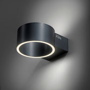 Moderne Wandleuchte PURE CLIPSE von Paul Neuhaus in seitlicher Perspektive, mit rundem, schwarzem Gehäuse und leuchtendem LED-Ring.