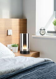 Moderne LED-Tischleuchte auf einem Nachttisch, seitliche Perspektive