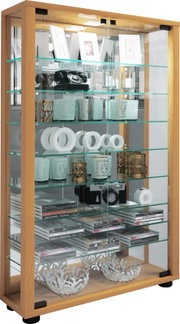 Hohe Glasvitrine mit Holzrahmen und mehreren Glasböden, befüllt mit Dekoartikeln und Büchern, frontale leicht seitliche Perspektive