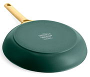 Rückansicht einer grünen Bratpfanne mit gelbem Griff, auf einer weißen Oberfläche liegend.