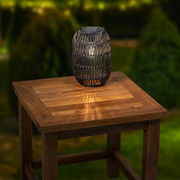 Solar Laterne aus Eisen auf einem Holztisch, von schräg oben fotografiert, mit warmem Lichtschein.