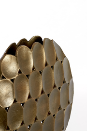 Nahaufnahme einer goldenen Vase mit ovalen, strukturierten Elementen und wellenförmigem Rand, seitliche Perspektive.