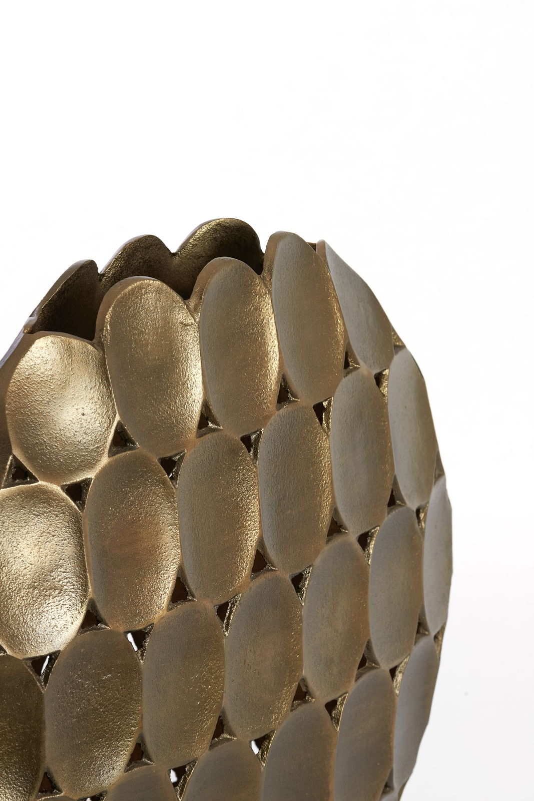 Nahaufnahme einer goldenen Vase mit ovalen, strukturierten Elementen und wellenförmigem Rand, seitliche Perspektive.