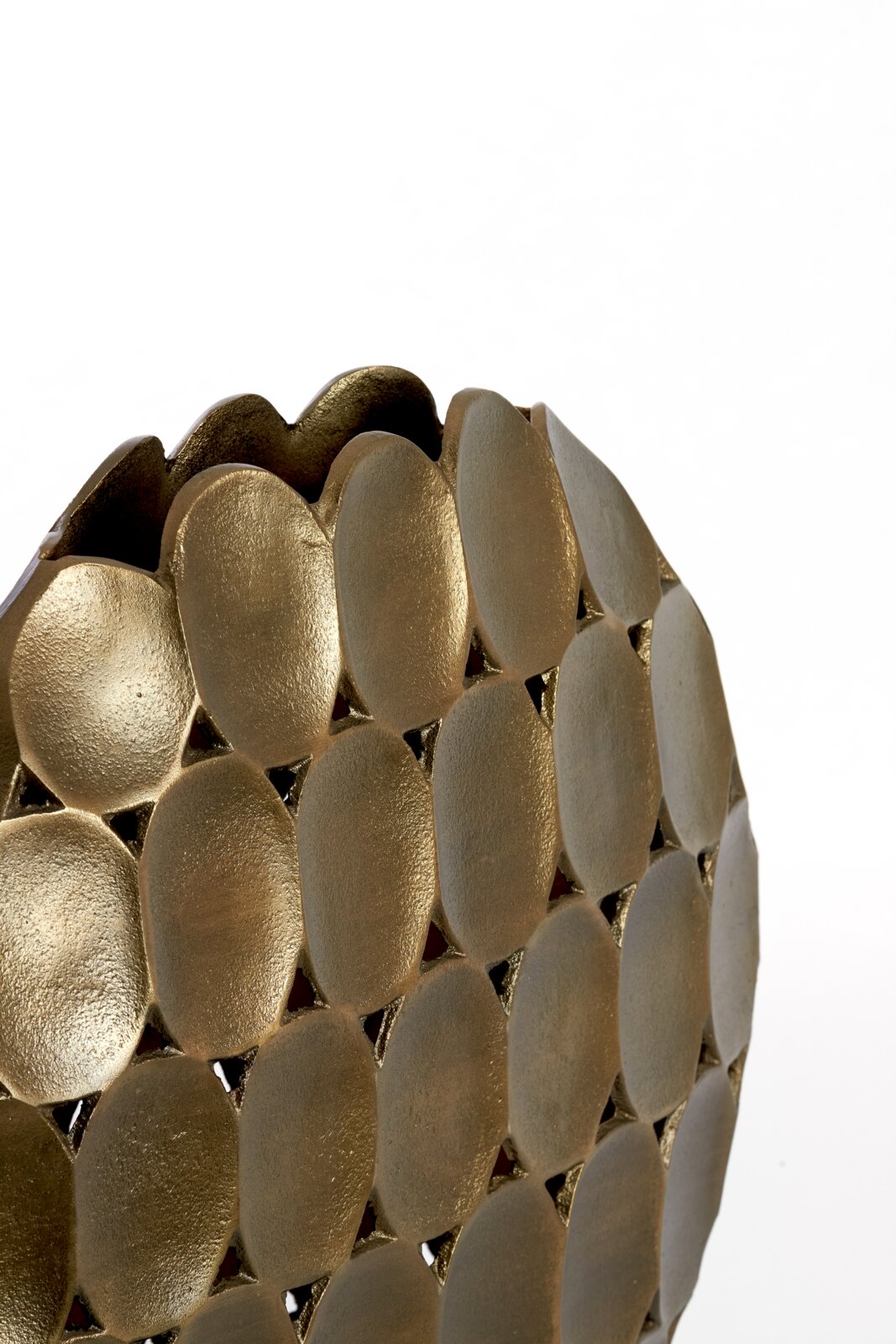 Nahaufnahme einer goldenen Vase mit ovalen, strukturierten Elementen und wellenförmigem Rand, seitliche Perspektive.