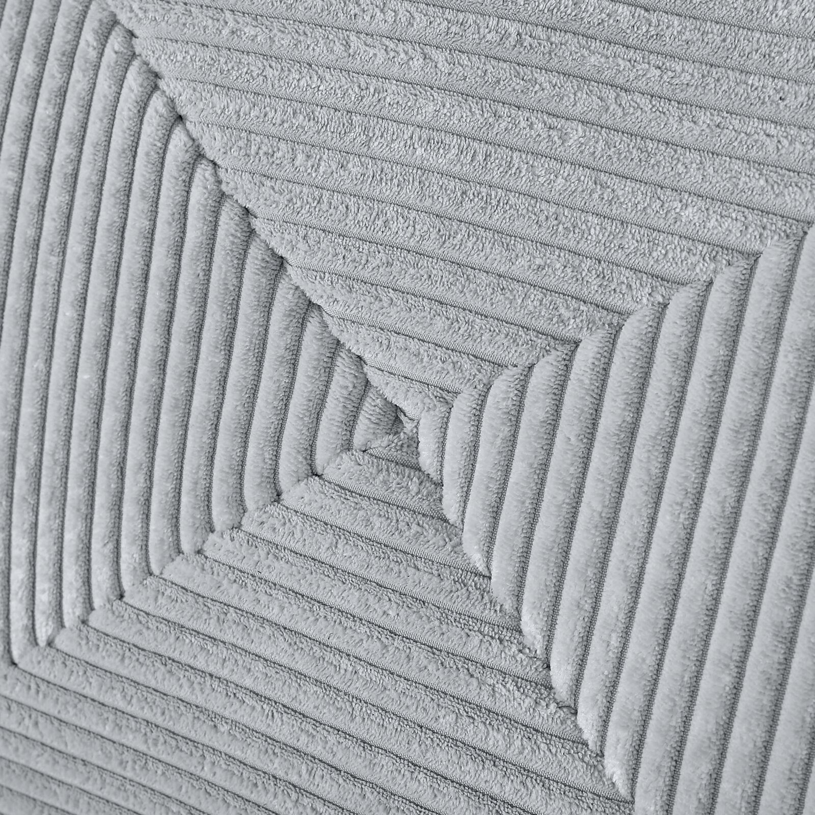 Close-up van een grijze, gestructureerde stof met diagonale lijnen op een functionele bank.