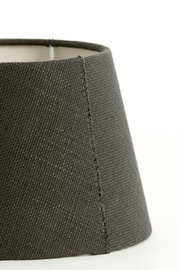 Nahaufnahme eines runden, grauen Lampenschirms aus Stoff, seitliche Perspektive