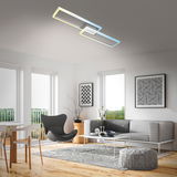 Moderne LED Deckenleuchte in aluchrom, rechteckiges Design, von unten betrachtet in einem stilvollen Wohnzimmer mit grauem Sofa und dekorativen Elementen.
