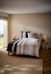 Bettwäsche-Set in einem modernen Schlafzimmer mit Streifenmuster in Beige- und Schwarztönen, seitliche Perspektive