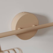 Beige wandmontierte Handtuchstange mit runder Wandhalterung in Nahaufnahme, schräg von unten/seitlich fotografiert