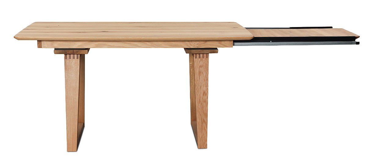 Erweiterbarer Esstisch aus Holz in Seitenansicht mit ausgezogener Tischplatte.