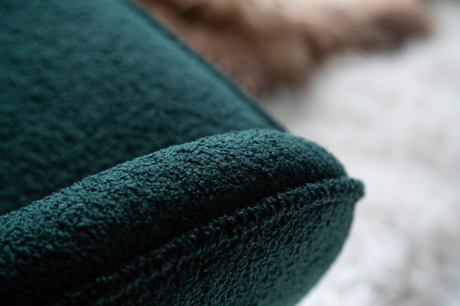 Nahaufnahme eines dunkelgrünen Schaukelstuhls mit weicher Textur, seitliche Perspektive