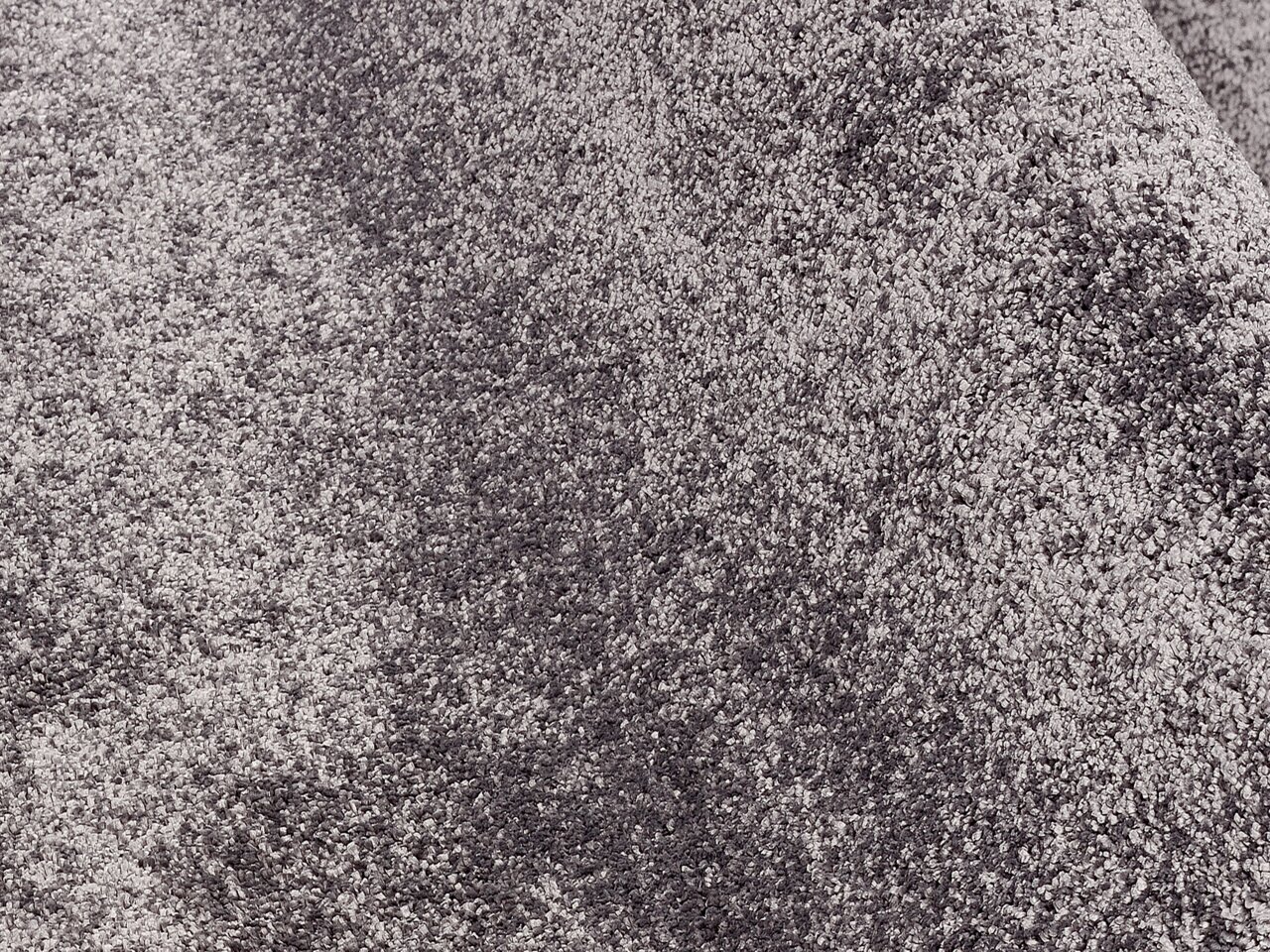 Nahaufnahme eines grauen Uni-Teppichs mit weicher Textur.