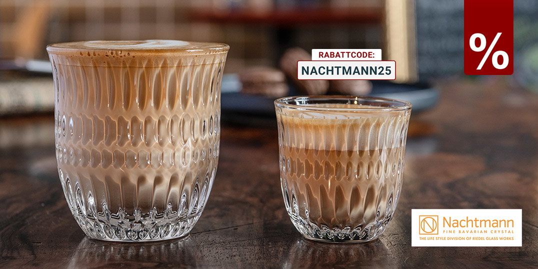 Zwei strukturierte Nachtmann Kristallgläser mit Latte Macchiato und Espresso auf Holztisch in stilvollem Café-Ambiente.