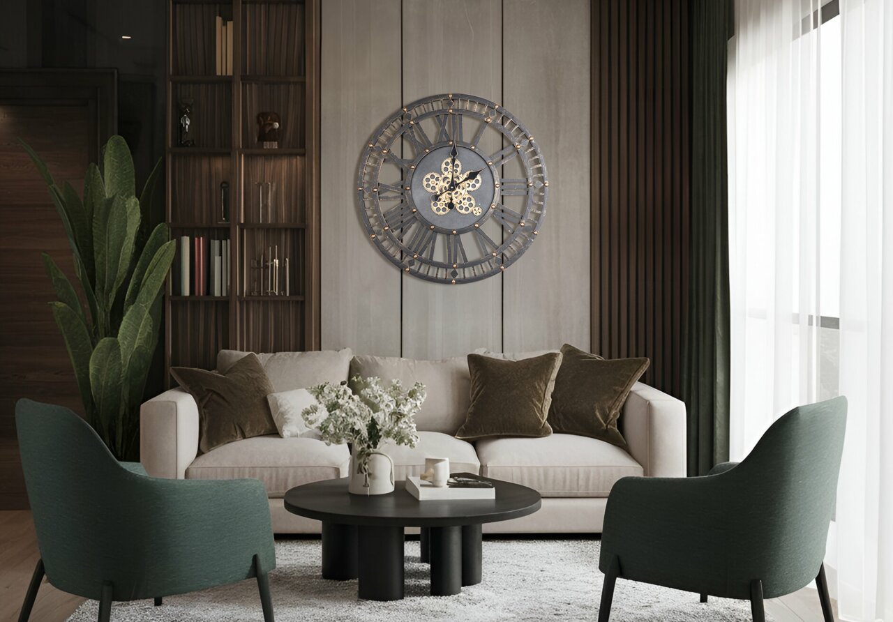 Grote, decoratieve wandklok met Romeinse cijfers en tandwielen, aan de muur in de woonkamer boven een bank bevestigd.