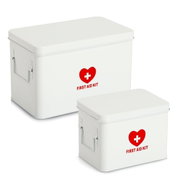 Zwei weiße Medizinboxen mit rotem Herz und Kreuz, Aufschrift 'FIRST AID KIT', aus seitlicher Perspektive.