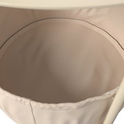 Nahaufnahme eines beigen Beistelltisches mit Stoffeinsatz von oben betrachtet.