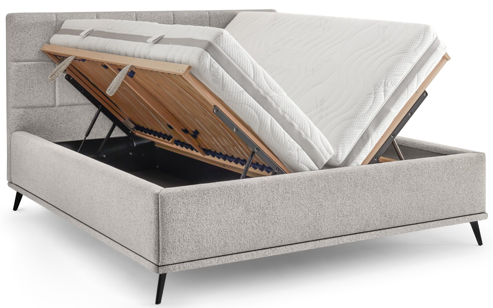 Gepolstertes graues Boxspringbett mit geöffnetem Stauraum und hochklappbarem Lattenrost, Matratzen angehoben; Ansicht schräg von vorne.