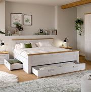 Weißes Holzbett mit naturfarbenen Akzenten und zwei ausgezogenen Unterbett-Schubladen im modern eingerichteten Schlafzimmer, Perspektive: frontale 3/4-Ansicht von leicht schräg rechts.