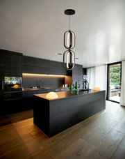 Moderne LED-Hängeleuchte in einer stilvollen, dunklen Küche, von unten betrachtet.