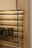 Detailansicht eines Highboards aus Holz mit Glasregalen und LED-Beleuchtung, Perspektive von der Seite.