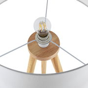 Nahaufnahme einer Stehleuchte mit Holzstativ und sichtbarer Glühbirne von oben betrachtet.