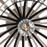 Nahaufnahme einer Deckenleuchte mit radial angeordneten schwarzen Streben und sichtbarer Glühbirne von unten.