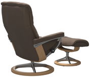 Rückansicht eines braunen Einzelsessels mit passendem Hocker, beide mit Holz- und Metallgestell.