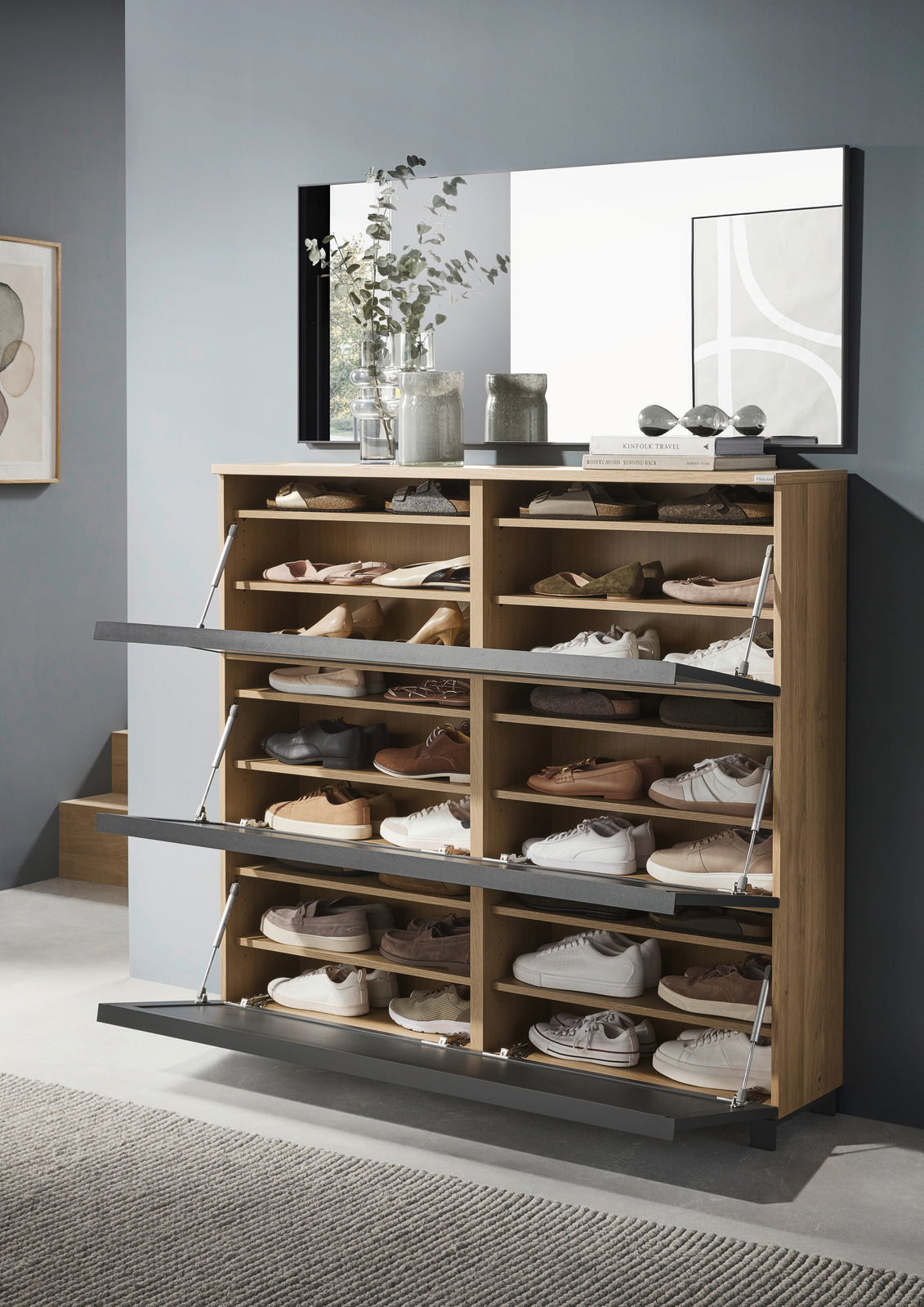 Moderner XL-Schuhschrank aus Holz mit mehreren Klappfächern, gefüllt mit verschiedenen Schuhen, in einer stilvollen Raumumgebung. Frontalansicht.