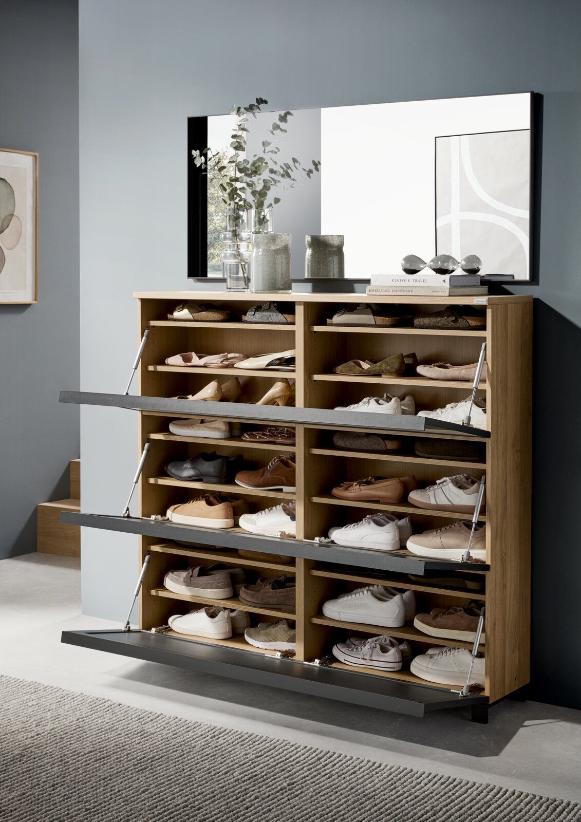 Moderne XL-schoenenkast van hout met meerdere klapvakken, gevuld met diverse schoenen, in een stijlvolle interieuromgeving. Vooraanzicht.